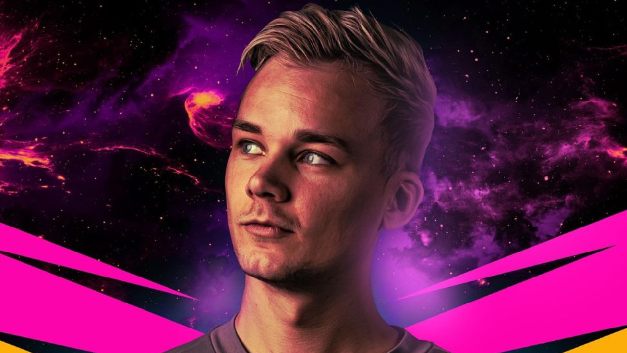 An electrifying image of Adrenalize, the Danish DJ and music producer, performing live on stage. He's surrounded by vibrant, colorful lights and a crowd of fans waving their hands in the air, fully immersed in the high-energy atmosphere. Adrenalize is wearing a casual yet stylish outfit, focused intently on his DJ equipment as he mixes music for the crowd.